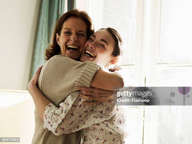 portrait of mother and daughter embracing - daughter stock-fotos und bilder