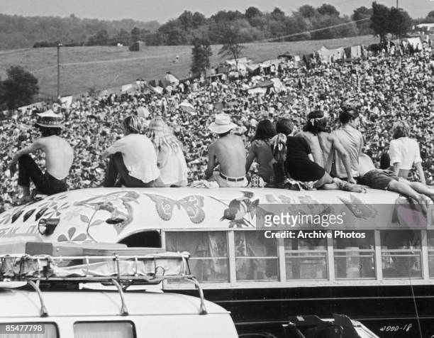 Fans sitting on top of a painted bus at the Woodstock Music Festival, Bethel, New York, 15th-17th August 1969.