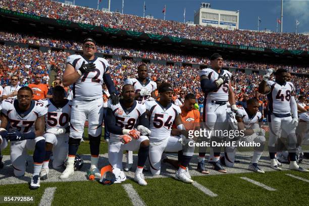 Denver Broncos Garett Bolles , Derek Wolfe and Shaquil Barrett with teammates kneeling and linking arms in a show of solidarity during the National...