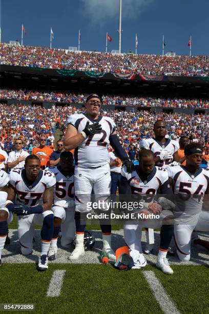 Denver Broncos Garett Bolles with teammates kneeling and linking arms in a show of solidarity during the National Anthem before game vs Buffalo Bills...