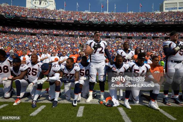 Denver Broncos Garett Bolles and Derek Wolfe with teammates kneeling and linking arms in a show of solidarity during the National Anthem before game...