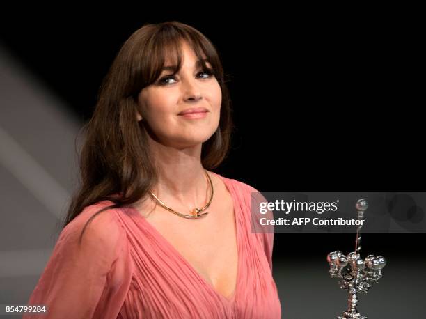 Italian actress Monica Bellucci holds her Donostia Award for her prestigious film career during the 65th San Sebastian Film Festival, in the northern...