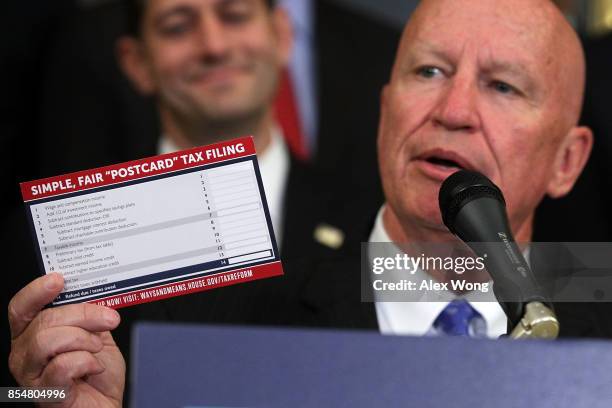 Rep. Kevin Brady holds up a tax filing "postcard" as Speaker of the House Rep. Paul Ryan looks on during a press event on tax reform September 27,...