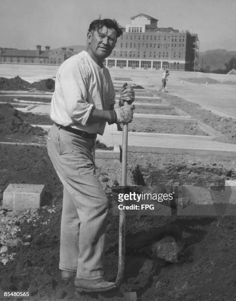 American athlete and Olympic gold medallist Jim Thorpe works as a labourer on the site of County Hospital, Los Angeles, circa 1930.