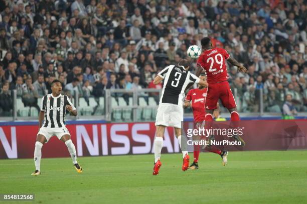 Giorgio Chiellini and Emmanuel Emenike compete for the ball during the UEFA Champions League football match between Juventus FC and Olympiakos FC at...