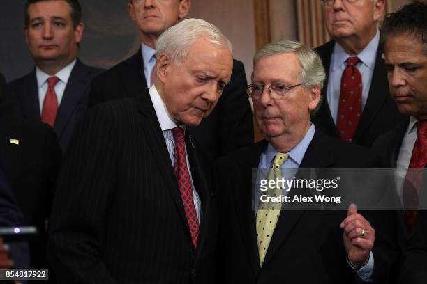Senate Majority Leader Sen. Mitch McConnell listens to Sen. Orrin Hatch as they attend a press event on tax reform other congressional Republicans...