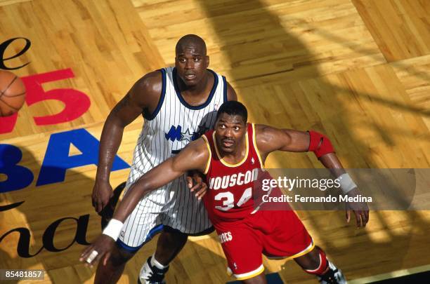 Hakeem Olajuwon of the Houston Rockets boxes out againt Shaquille O'Neal of the Orlando Magic during Game One of the 1995 NBA Finals played on June...