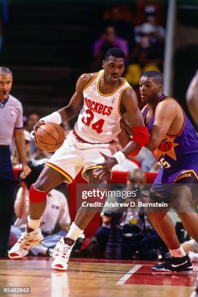 Hakeem Olajuwon of the Houston Rockets posts up against Oliver Miller of the Phoenix Suns during Game One of the Western Conference Semifinals played...