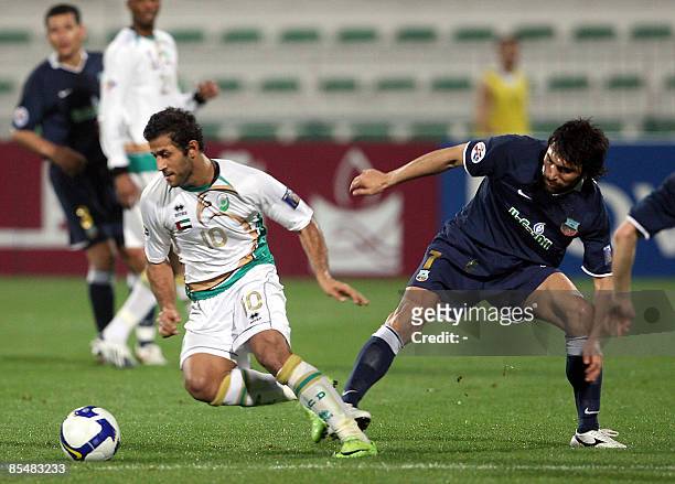Emirati al-Shabab's Iranian player Mehradad Oladi fights for the ball with Uzbek Bunyodkor's Aziz Haidarov during their AFC Champions League group D...
