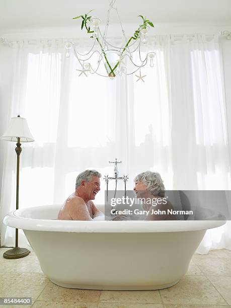 senior couple in bath together laughing - norman elder stock-fotos und bilder