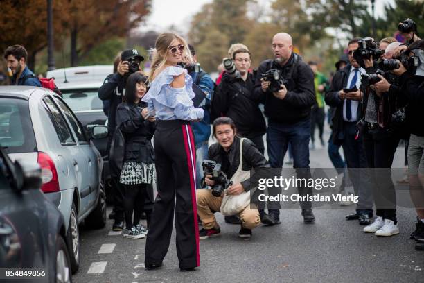 Xenia van der Woodsen in front of street style photographers wearing high waisted pants, Givenchy clutch, ripped off top is seen outside Lanvin...