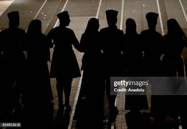 Silhouettes of a folk dance group are seen ahead of the 13th World Championship, amongst men and VI World Championship amongst women in fire and...