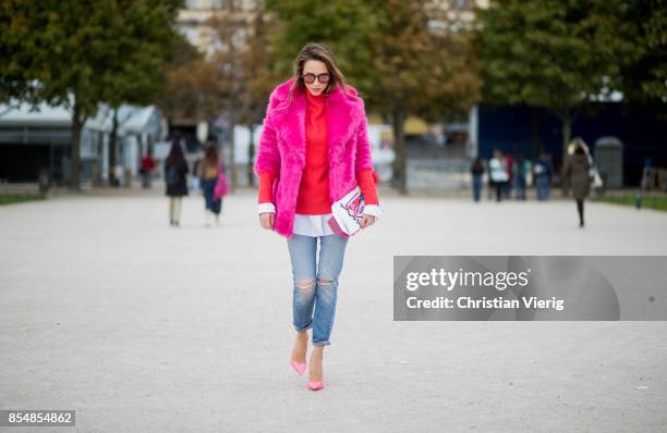 Alexandra Lapp wearing a fake fur jacket in pink from Jakke with a Faux Real statement on the back, red cashmere jumper by Heartbreaker with golden...