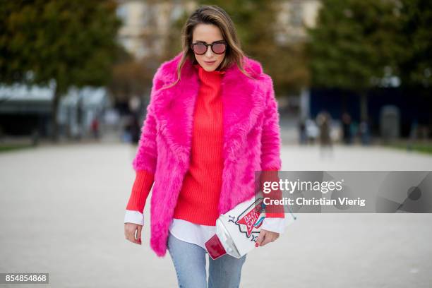 Alexandra Lapp wearing a fake fur jacket in pink from Jakke with a Faux Real statement on the back, red cashmere jumper by Heartbreaker with golden...