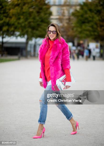 Alexandra Lapp wearing a fake fur jacket in pink from Jakke with a Faux Real statement on the back, red cashmere jumper by Heartbreaker with golden...