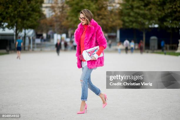 Alexandra Lapp wearing a fake fur jacket in pink from Jakke with a Faux Real statement on the back, red cashmere jumper by Heartbreaker with golden...