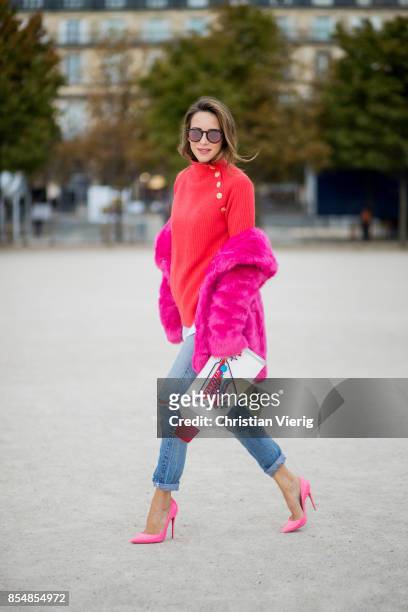 Alexandra Lapp wearing a fake fur jacket in pink from Jakke with a Faux Real statement on the back, red cashmere jumper by Heartbreaker with golden...