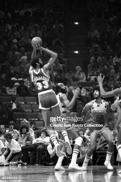 Center Kareem Abdul-Jabbar of the Los Angeles Lakers attempts a jumpshot in front of center Nate Thurmond and forward Rowland Garrett of the...