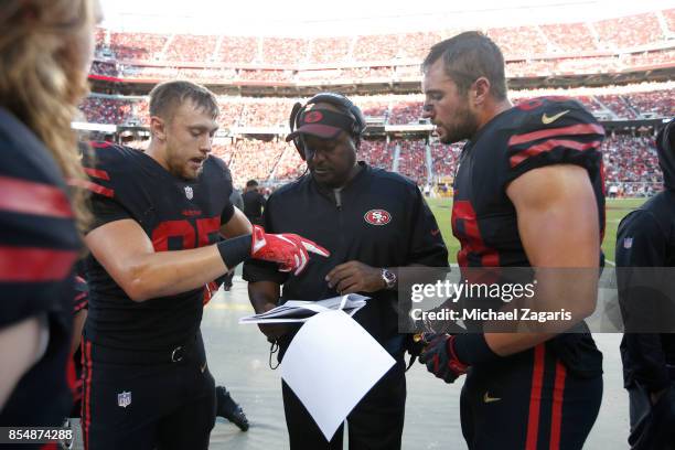 Logan Paulsen, George Kittle, Tight Ends/Assistant Head Coach Jon Embree and Garrett Celek of the San Francisco 49ers talk on the sideline during the...