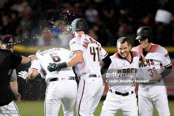 David Peralta of the Arizona Diamondbacks celebrates with teammates after a bases loaded walk in the ninth inning to score the winning run against...