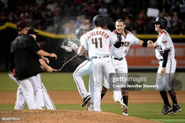 David Peralta of the Arizona Diamondbacks celebrates with teammates after a bases loaded walk in the ninth inning to score the winning run against...