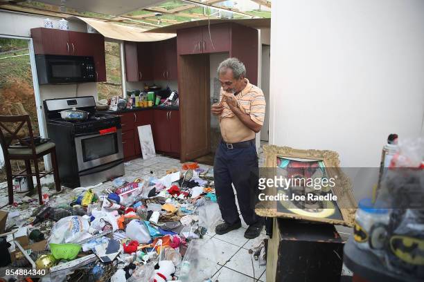 Ramon Torres stands in what is left of his sister-in-law's home as they salvage what they can from the home that was destroyed when Hurricane Maria...