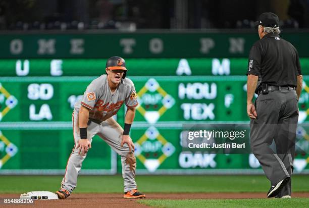 Austin Hays of the Baltimore Orioles reacts after being tagged out by Sean Rodriguez of the Pittsburgh Pirates as part of a double play in the first...