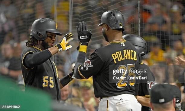 Josh Bell of the Pittsburgh Pirates high fives with Gregory Polanco after hitting a two run home run in the third inning during the game against the...