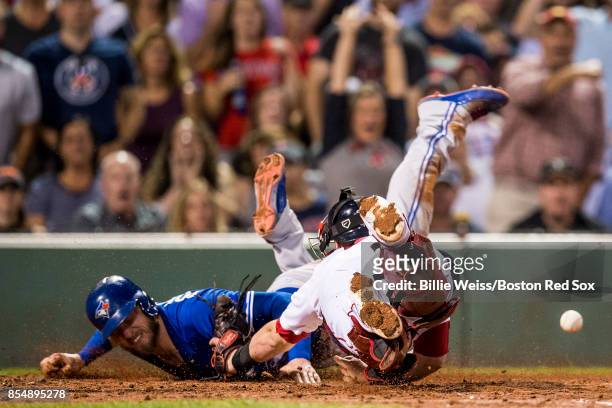 Josh Donaldson of the Toronto Blue Jays evades the tag of Christian Vazquez of the Boston Red Sox as he scores during the third inning of a game on...