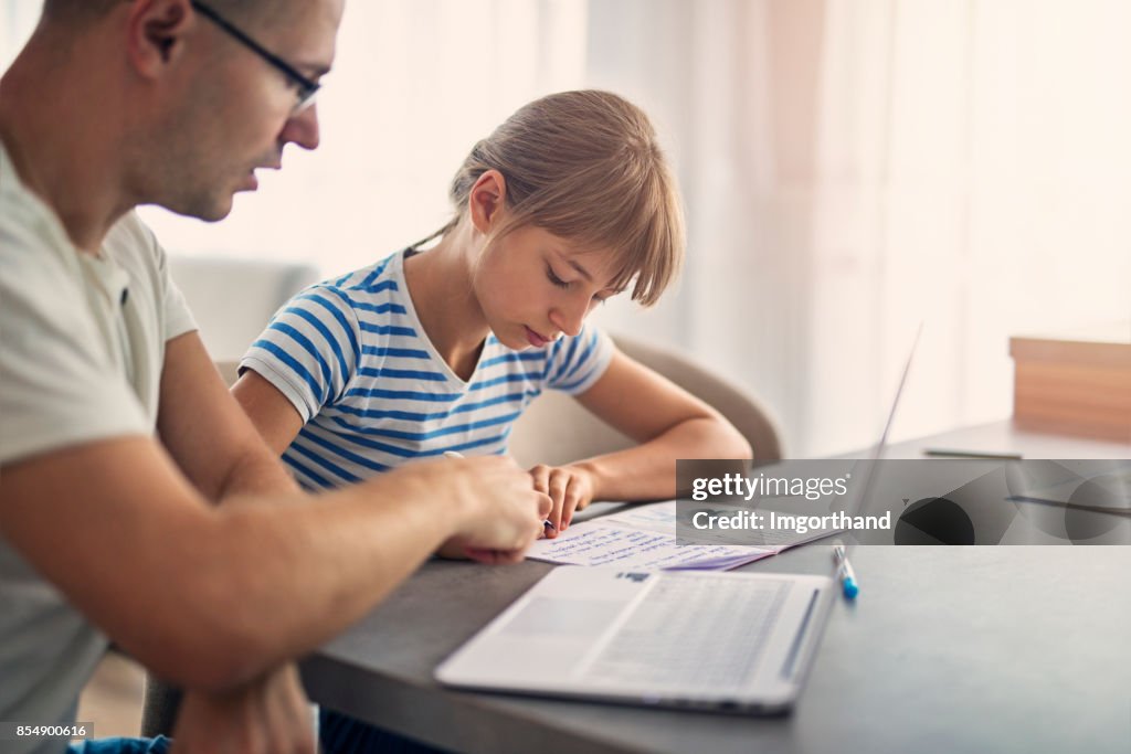 Filha de pai ajudando a fazer a lição de casa