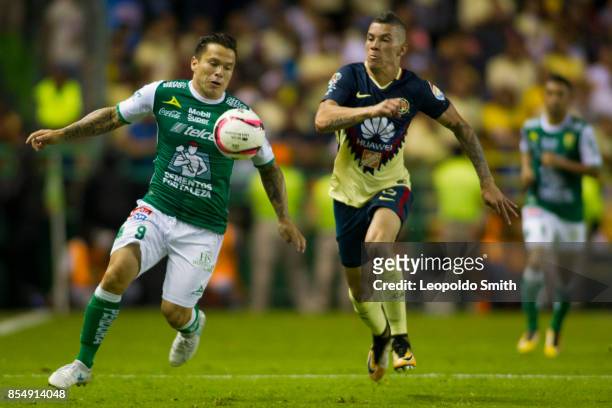 Alvaro Ramos of Leon fights for the ball with Andres Uribe of America during the 11th round match between Leon and America as part of the Torneo...