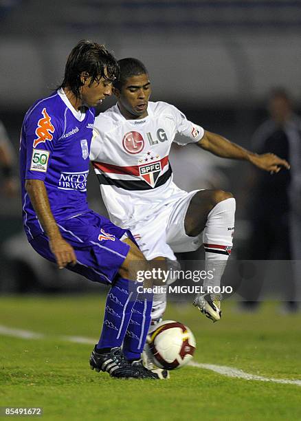 Junior Cesar of Brazil's Sao Paulo vies for the ball with Sergio Ariosa of Uruguay's Defensor during a Libertadores Cup football match in Montevideo,...