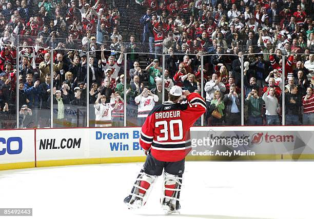 Goaltender Martin Brodeur of the New Jersey Devils salutes the crowd with a tip of his hat after defeating the Chicago Blackhawks 3-2 and becoming...