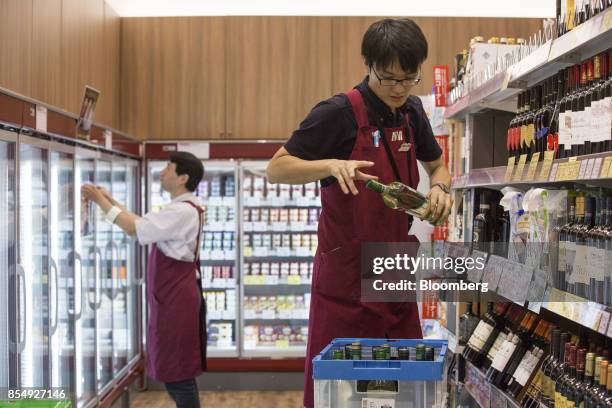 Employees stock shelves at a Seijo Ishii Inc. Grocery store inside the Trie Keio Chofu Shopping Center, operated by Keio Corp., in Chofu, Tokyo, on...