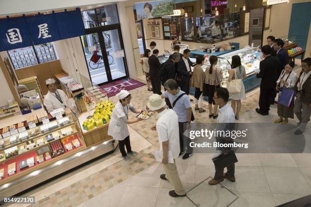 An employee of a confectionery store offers tasting samples during a media tour of the Trie Keio Chofu Shopping Center, operated by Keio Corp., in...