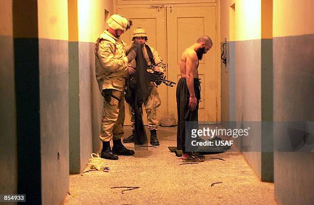 An English speaking Taliban prisoner is processed and carefully strip searched and secured for transport December 30, 2001 from Mazar-e Sharif to...