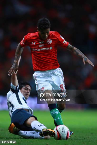 Jesus Mendez of Toluca struggles for the ball with Mauro Formica of Pumas during the 11th round match between Toluca and Pumas UNAM as part of the...