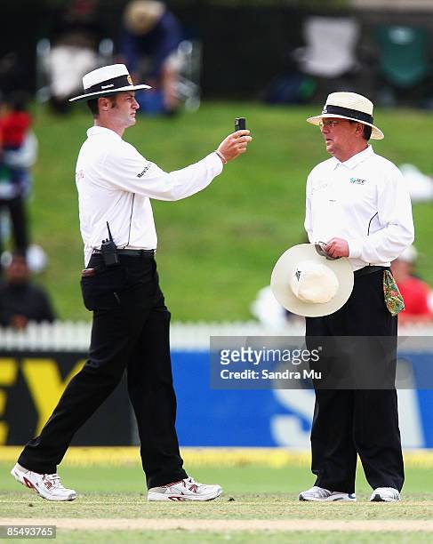 Umpires Simon Taufel and Ian Gould check the light conditions before calling the game off during day two of the First Test match between New Zealand...