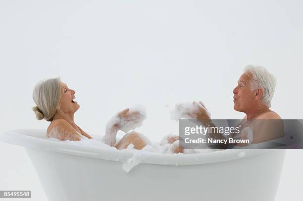 senior caucasian couple in bubble  bath - couples showering stock-fotos und bilder