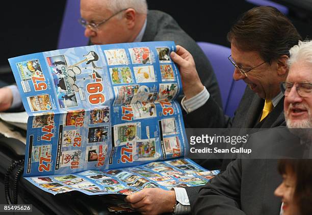 German Social Democrat Klaus Uwe Benneter reads the ads of a leading German consumer electronics retailer before a declaration by Chancellor Angela...