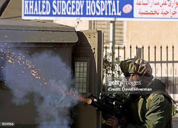 An Israeli soldier fires a tear gas grenade at Palestinian stone-throwers January 4, 2002 in the West Bank town of Ramallah, where the Israeli army...