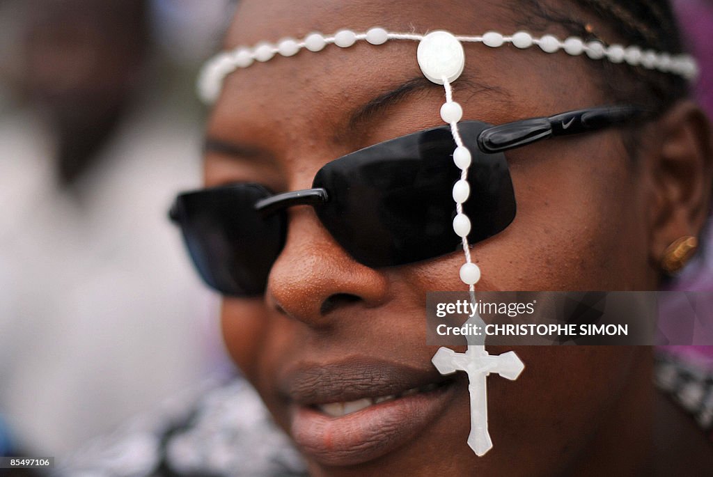 An African woman wears a cross outside o
