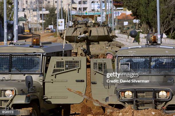 An Israeli soldier readies himself to fire tear gas grenade at Palestinian stone-throwers January 4, 2002 in the West Bank town of Ramallah, where...