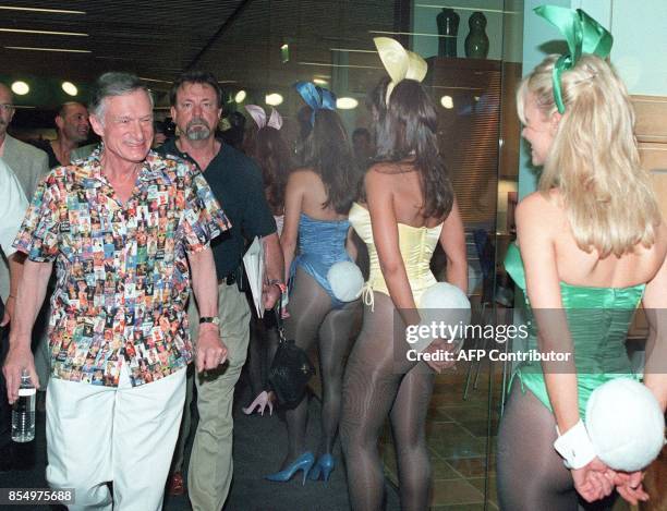 Playboy Magazine & Entertainment company owner Hugh Hefner eyes Playboy "Bunnies" as he arrives at an expo to commemorate Playboy's 45th anniversary,...