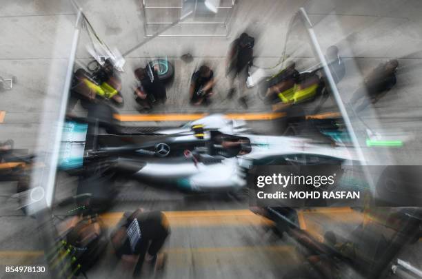 Team members of Mercedes' British driver Lewis Hamilton practice a pit stop ahead of the Formula One Malaysia Grand Prix in Sepang on September 28,...