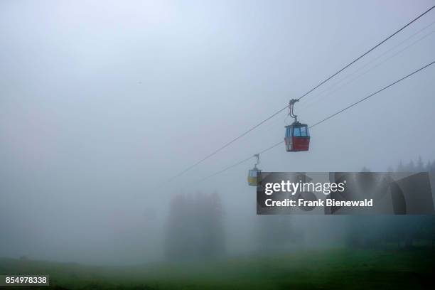 Two gondolas of the cable-car to Männlichen are coming out of the clouds.