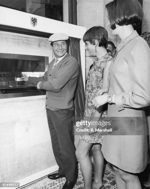 English actor Reg Varney makes the first withdrawal from a Barclaycash machine, at the Enfield branch of Barclays Bank, 27th June 1967. The Enfield...