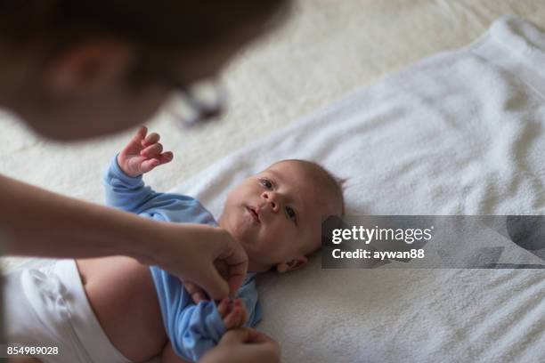 tijd om te veranderen van een romper - moms crying in bed stockfoto's en -beelden