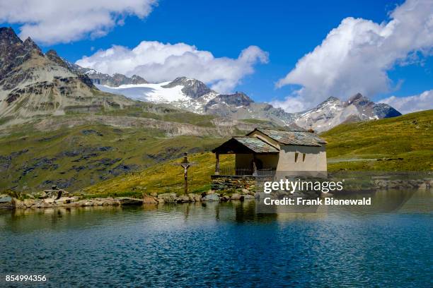 The Lake Black, Schwarzsee with the Chapel Mary of the Snows, Maria zum Schnee, high mountains in the distance.