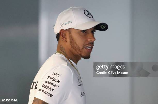 Lewis Hamilton of Great Britain and Mercedes GP talks in the garage during previews for the Malaysia Formula One Grand Prix at Sepang Circuit on...